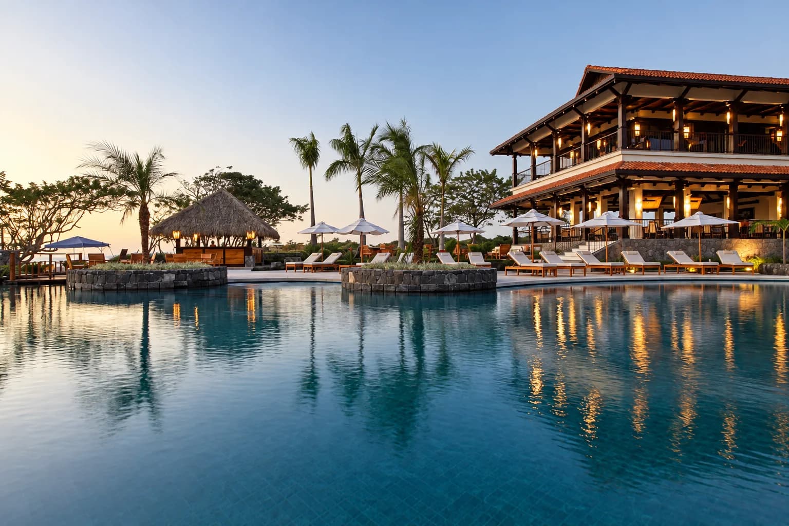 The beach club at Hacienda Pinilla at dusk, its lights reflected in the pool